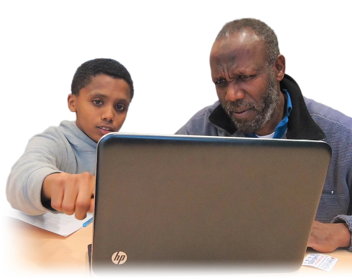 A youth tutor showing a senior man something on a laptop